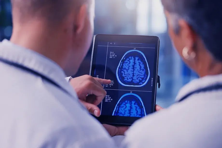 backshot of two people looking at scans on tablet