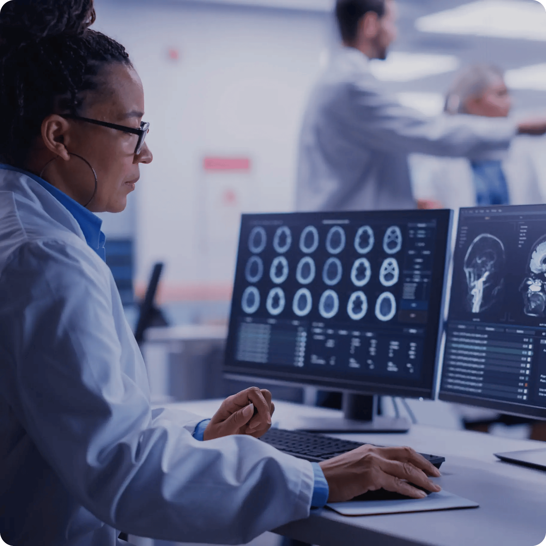 woman looking at brain scans on monitors