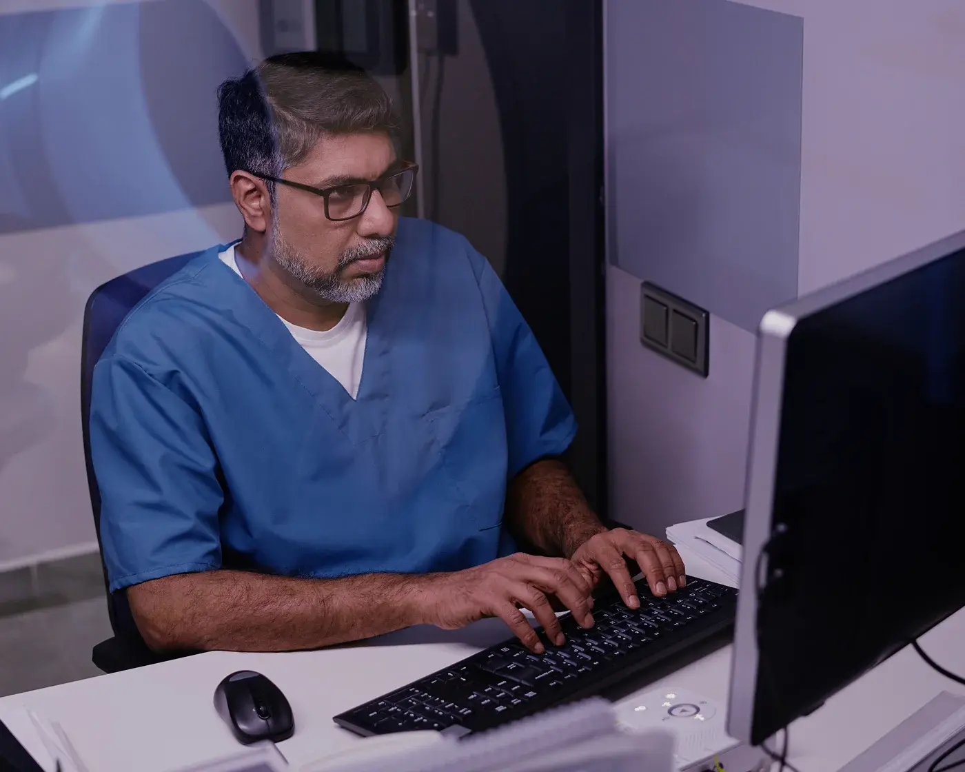 male nurse typing on keyboard