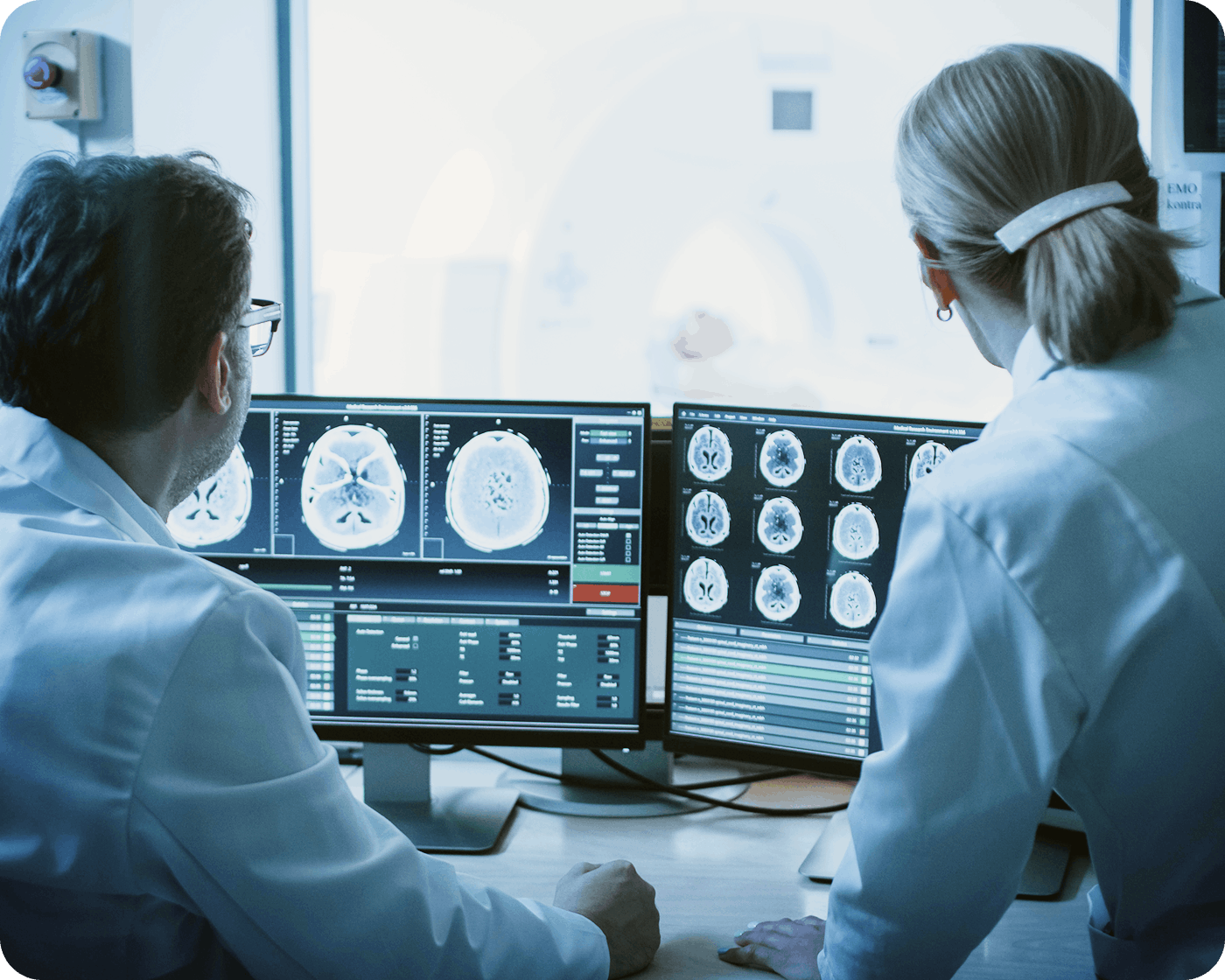 backshot of two doctors loking at brain scans on screens